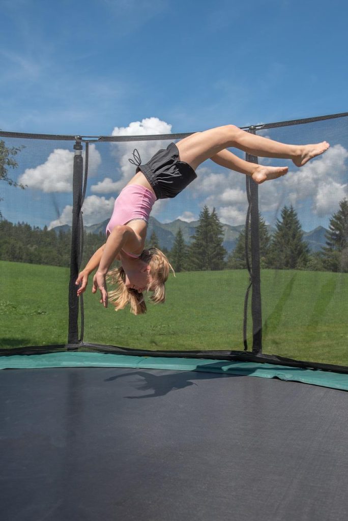 Familie die samen springt op een veilige trampoline in de tuin, met gezondheidsvoordelen en plezier